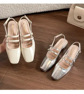Détail de sandales à bout carré en beige verni et argent métallisé avec doubles brides