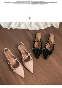 Detalle de elegantes tacones destalonados con tachuelas doradas en correas finas dobles