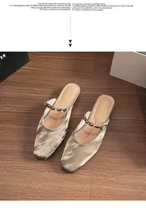 Close-up of silver velvet mule shoe with marble texture and golden rivet buckle