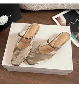 Close-up of champagne square toe mule shoes with brushed texture and gold rivets