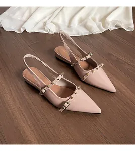 Detalle de bailarinas destalonadas nude con tachuelas doradas y punta fina elegante