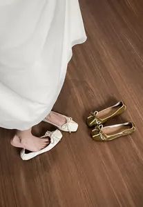 Dettaglio di ballerine a punta quadrata con fiocco di perle in beige e verde oliva