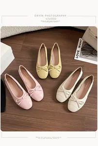 Bailarinas planas con textura tejida y lazo mostradas en suelo de madera