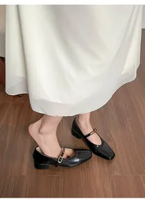 Draufsicht auf französische Mary Jane Halbschuhe aus schwarzem Lackleder mit goldener Schnalle