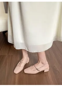 Detail of nude pink patent leather slingback Mary Jane shoes with low square heel