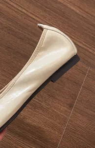Dettaglio di ballerine beige crema con trama in pelle di qualità e tacco basso comodo