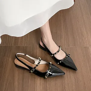 Sandalias planas de punta fina en charol negro con tachuelas doradas estilo francés