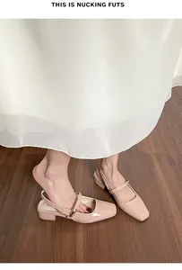 Detailed view of beige patent leather slingback shoes with square toe and gold buckle