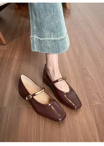 Detail von dunkelbraunen Mary Jane Schuhen aus Lackleder mit eckiger Zehenpartie