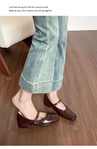 Nahaufnahme brauner Mary Jane Schuhe mit Karree-Zehe, Lackleder und Metallschnallenriemen