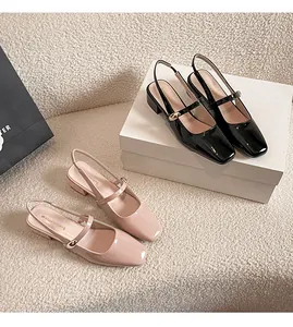 Close-up of beige and black patent leather slingback Mary Jane shoes with low block heels