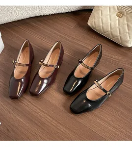 Nahaufnahme von Mary Jane Halbschuhen in glänzendem Schwarz und Bordeauxrot mit Blockabsatz