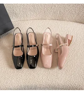 Top view of patent leather Mary Jane block heel sandals on soft textured ivory fabric