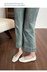 Nahaufnahme von weißen Ballerinas mit Schleife kombiniert mit blauer Jeanshose