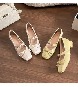 Top view of Mary Jane block heels with chic bows and square toes on wood background