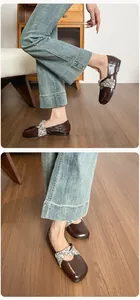 Dettaglio di ballerine francesi vintage con cinturini floreali e pelle marrone