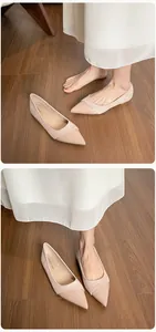 Close-up detail of nude pointed-toe flat shoes with glossy leather and matte textures