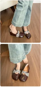 Dettaglio di ballerine Mary Jane in pelle marrone con cinturini floreali