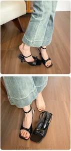 Detailansicht schwarzer Blockabsatz-Sandalen mit eleganter Schleife und eckiger Zehenpartie