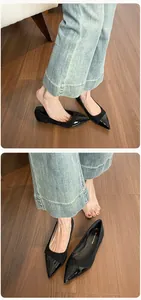 Close-up of black pointed-toe ballet flats with contrast textures and denim pairing