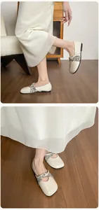 Dettaglio di ballerine Mary Jane color crema con cinturini incrociati a fantasia su modella