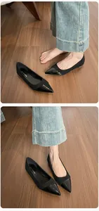 Detail view of black pointed toe flats featuring matte suede and glossy patent leather