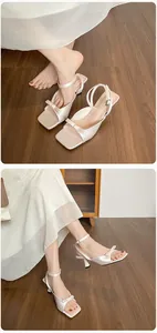 Detailansicht von perlweißen Satin-High-Heels mit Schleifenakzent und Knöchelriemen