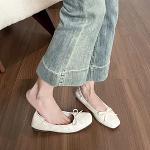 Elegante cremeweiße Ballerinas mit eckiger Zehenpartie und Schleife zu Jeanshosen