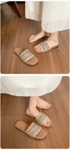 Détails de la bride tressée et de la semelle en PU souple sur des sandales plates marron