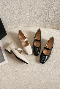 Top view of French Mary Jane pumps in beige and black patent leather with block heels