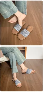 Détail de sandales plates tissées à rayures bleues et blanches sur parquet bois