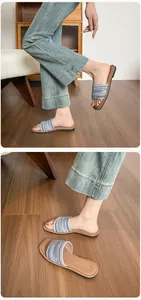 Détail des sandales plates pour femmes avec bride tissée bleue et blanche sur bois
