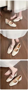 Detail view of cream patent leather Mary Jane shoes with square toe and block heels
