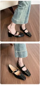 Detailed view of black patent leather Mary Jane pumps with elegant gold buckle and square toe