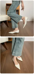 Detalle de bailarinas de charol crema con punta afilada y tacón bajo con vaqueros