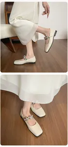 Macro view of French square toe Mary Jane flats with sparkling crystal floral buckle