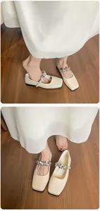 Detailed view of cream square toe ballet flats with sparkling rhinestone floral buckle