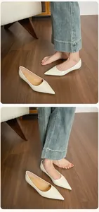 Primer plano de elegantes zapatos planos en punta color nude con acabado brillante