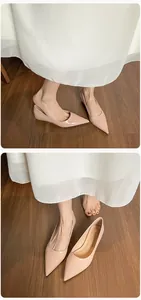 Primer plano de elegantes bailarinas de punta color beige con acabado de charol brillante