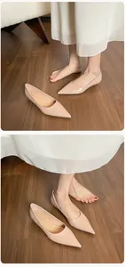 Primer plano de bailarinas beige de punta sobre suelo de madera y acabado brillante
