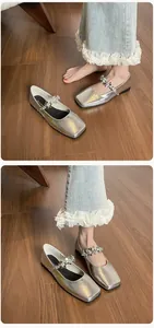 Detail of silver square-toe Mary Jane flats featuring three crystal flower decorations