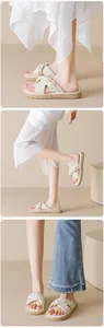 Detail view of cream platform sandals with knotted strap paired with a polka dot skirt
