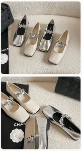 Macro detail of French style square toe Mary Jane flats with sparkling rhinestone flowers