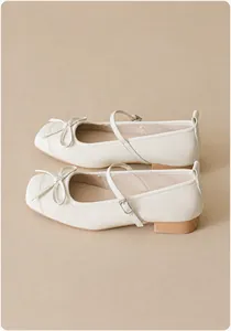 Detailed top view of off-white Mary Jane shoes featuring a classic bow and square toe