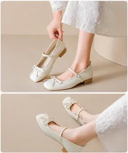Detailed side view of white Mary Jane shoes with square toe and elegant bow detail