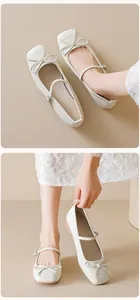 Detailed view of cream Mary Jane flat shoes featuring bow accent and square toe