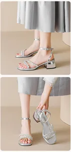 Macro detail of silver rhinestone sandals with chunky heel and adjustable ankle strap