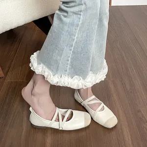 Ballerines Mary Jane beiges à brides croisées sur un sol en bois rustique