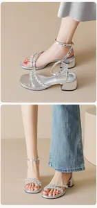 Close-up of shimmering rhinestones on silver block heel sandals with ankle strap design