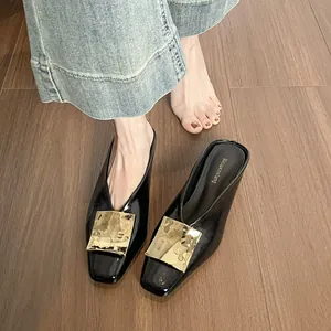 Klassische Pantoletten aus schwarzem Lackleder mit eckiger Zehenpartie und goldener Schnalle